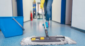 Close-up of cleaners moping the floor of a hall