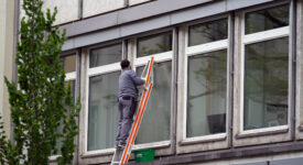 Window cleaner on leader at City of Zurich cleaning windows of office building. Photo taken May 7th, 2021, Zurich, Switzerland.