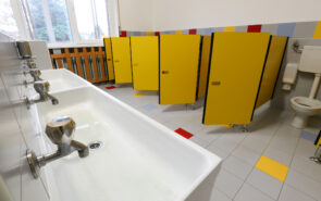 taps of washbasin and yellow doors in the bathroom of a nursery school without children