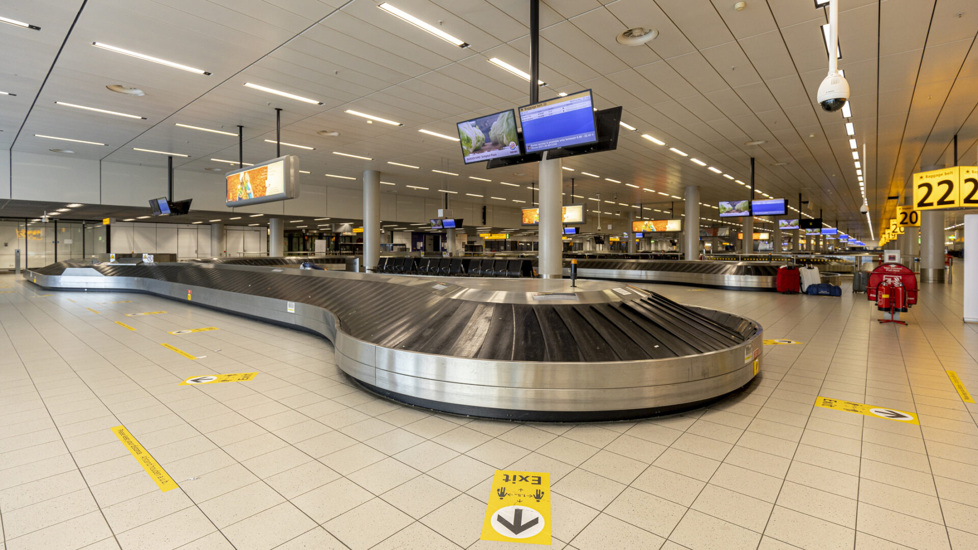 Amsterdam, Netherlands – July 22, 2020: Hallway with baggage claim conveyor belts in airport almost deserted during the COVID-19 coronavirus outbreak